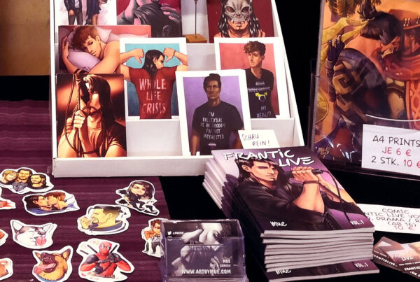 Stickers, Postcards, Prints and Comics laid out on a table at artist alley