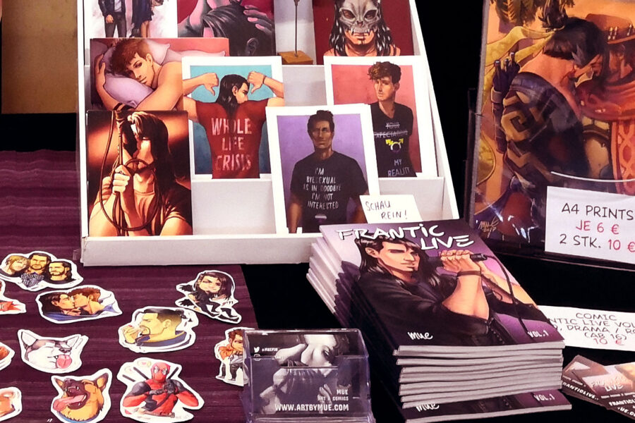 Stickers, Postcards, Prints and Comics laid out on a table at artist alley